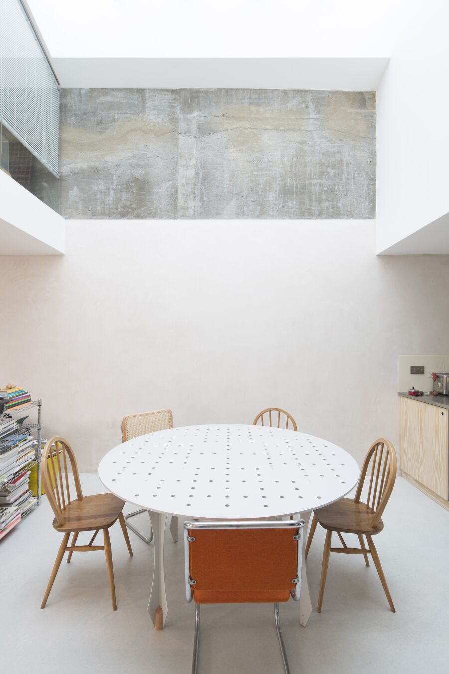 Perforated steel dining table in open plan dining area.