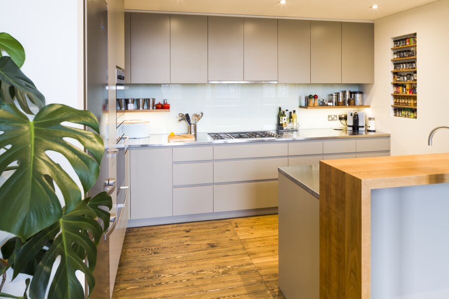 Modern kitchen with a mix of stainless steel and oak worktops, laminated plywood fronts and bespoke oak spice and plate racks..