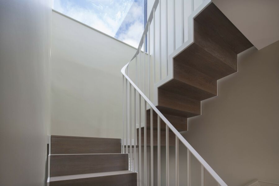 Powder-coated steel stairs with solid oak treads and riser on both sides..